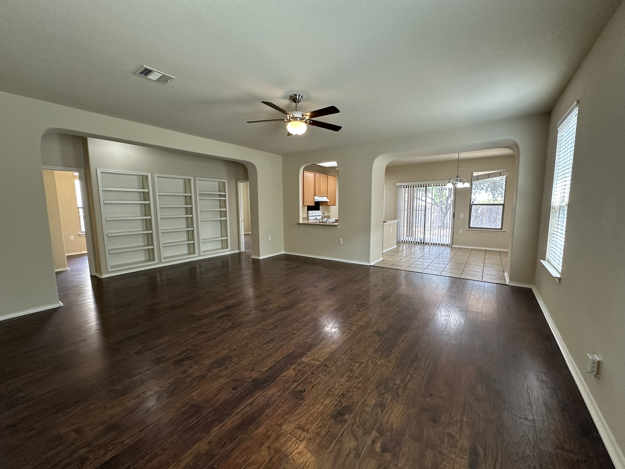 4507 Peach Grove Road Austin, TX 78744 - Photo 4 of 35 Gleaming hardwood floors and classic arched openings define this versatile open living space.