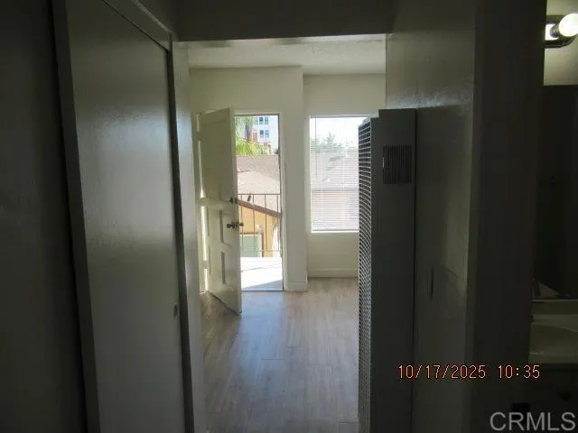 a hallway with a wooden floor and a window