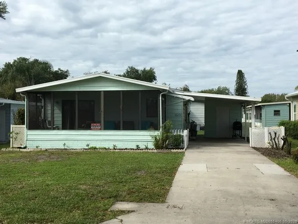 a front view of a house with a garden and yard