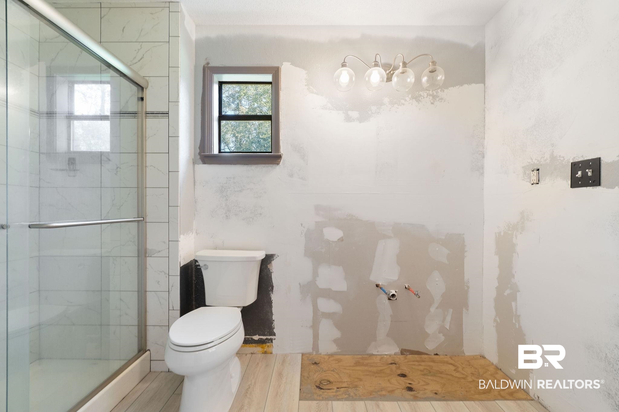 27300 C R Watson Road Robertsdale, AL 36567 - Photo 14 of 35 Bathroom featuring hardwood / wood-style flooring, toilet, and a shower with door