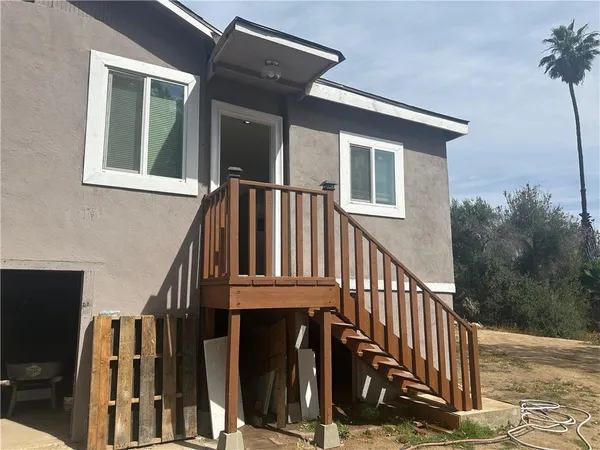 a view of wooden house with a deck