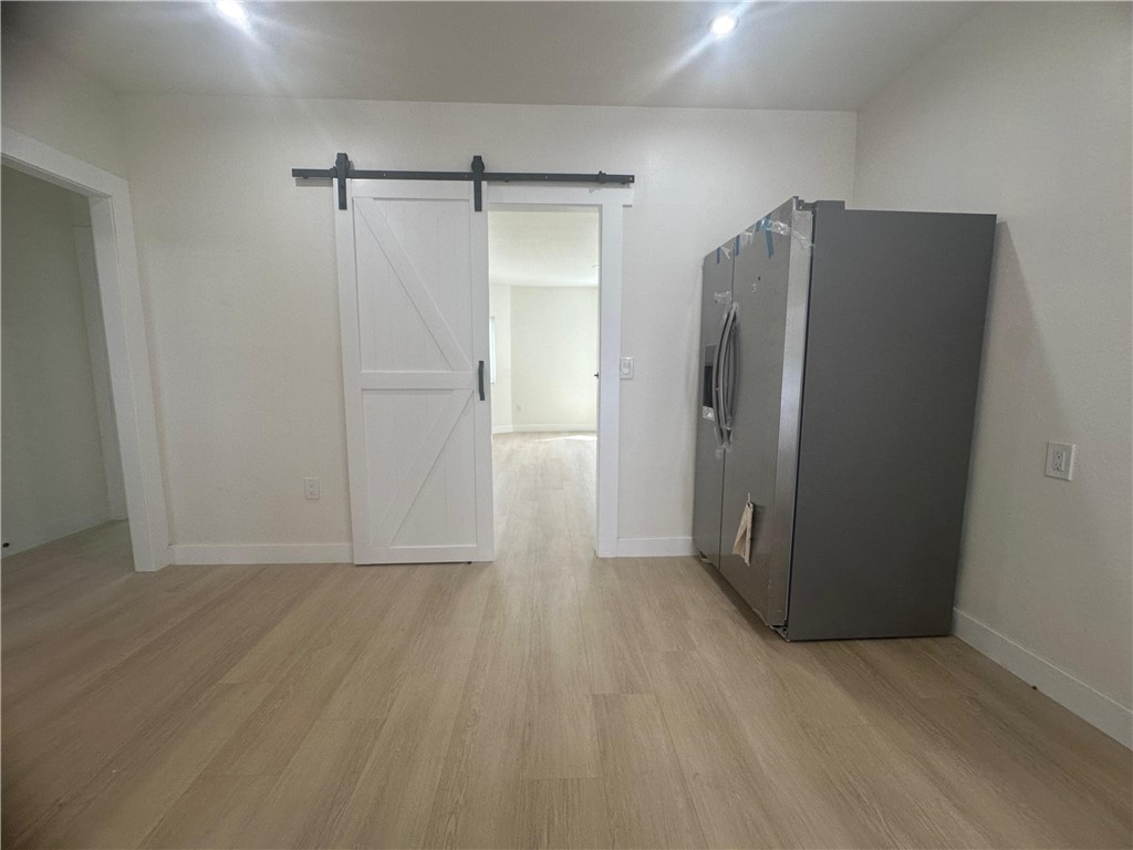 5778 La Sierra Avenue Riverside, CA 92505 - Photo 8 of 8 a view of an empty room with wooden floor and a bathroom