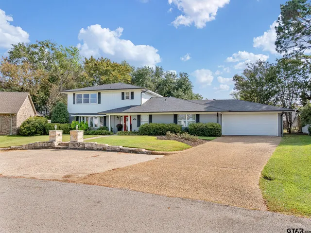 a front view of a house with yard and green space