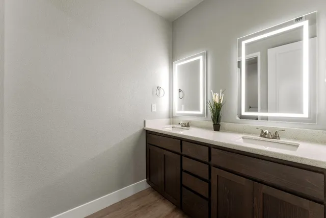 a bathroom with a double vanity sink and mirror