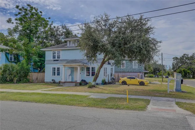 a view of a house with a big yard and large trees