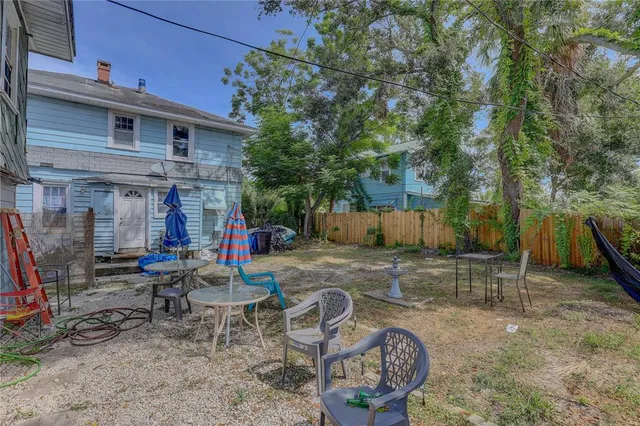 a view of a chairs and table in backyard of the house