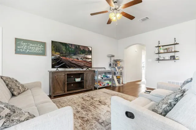 a living room with furniture a flat screen tv and a fireplace