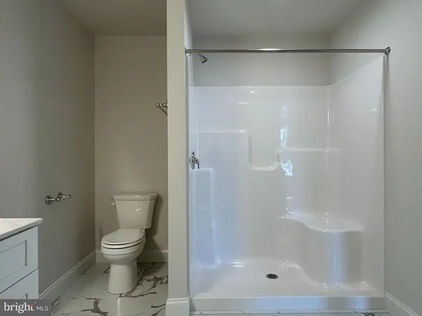 a white toilet next to a bathroom