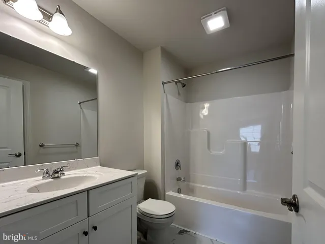 a bathroom with a double vanity sink toilet mirror and shower