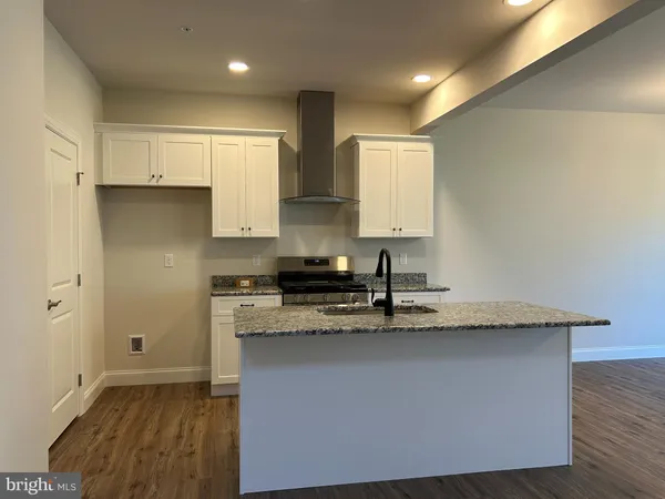 a kitchen with stainless steel appliances granite countertop a sink a stove and a refrigerator