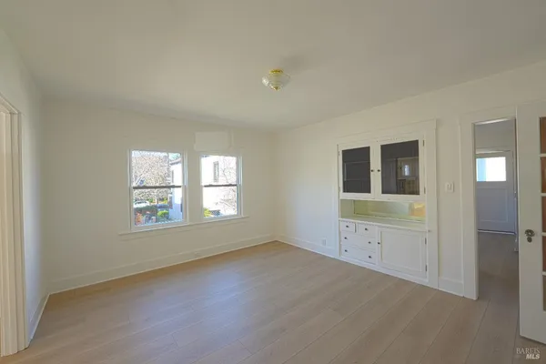 an empty room with windows and cabinet