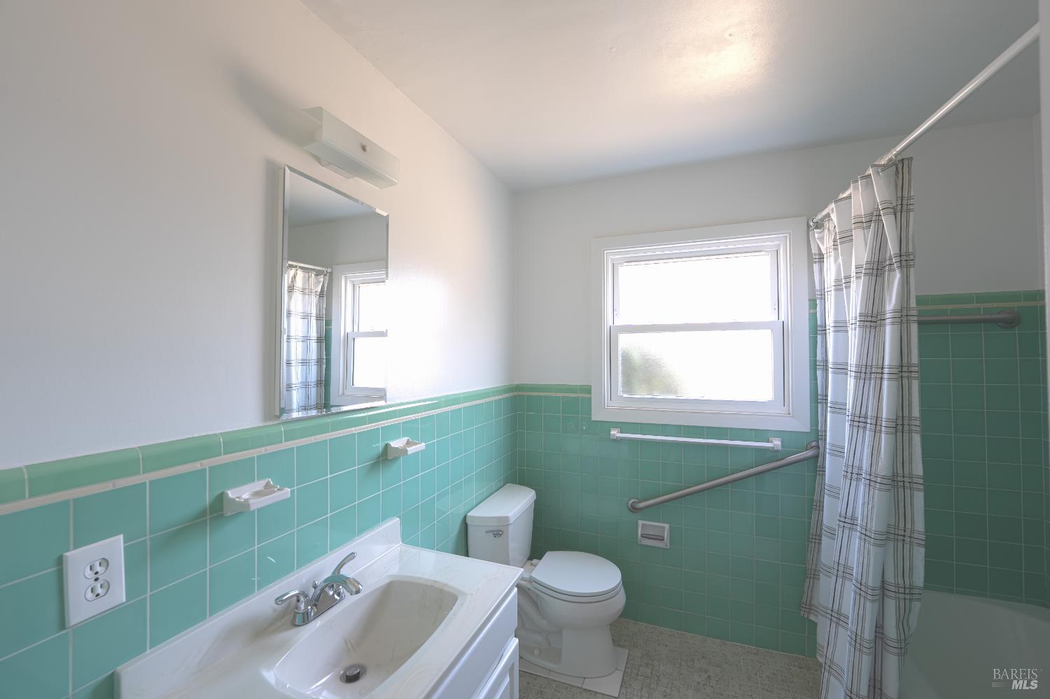 20 Taylor Street San Rafael, CA 94901 - Photo 19 of 22 a bathroom with a sink mirror toilet and window