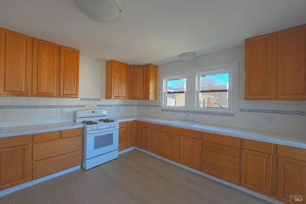 a kitchen with stainless steel appliances granite countertop wooden cabinets a sink and a window