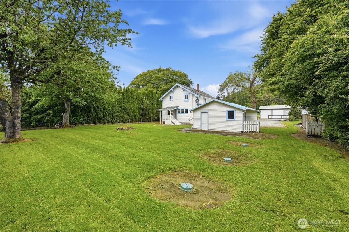 23746 Old Day Creek Road, Unit A & B Sedro-Woolley, WA 98284 - Photo 31 of 36 a view of a white house in front of a big yard with large trees