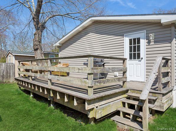337 Three Mile Harbor Road, Unit 10 East Hampton, NY 11937 - Photo 11 of 16 a view of a roof deck with couches and a yard