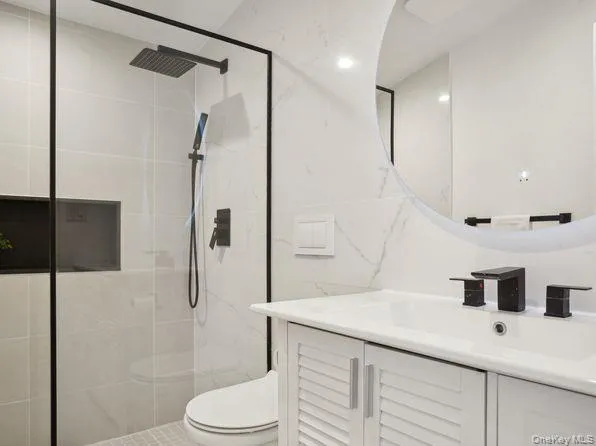 a bathroom with a sink a toilet and shower