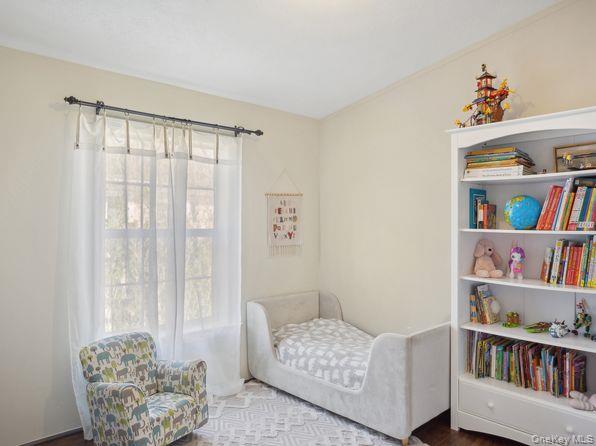 337 Three Mile Harbor Road, Unit 10 East Hampton, NY 11937 - Photo 6 of 16 a living room with furniture and a book shelf