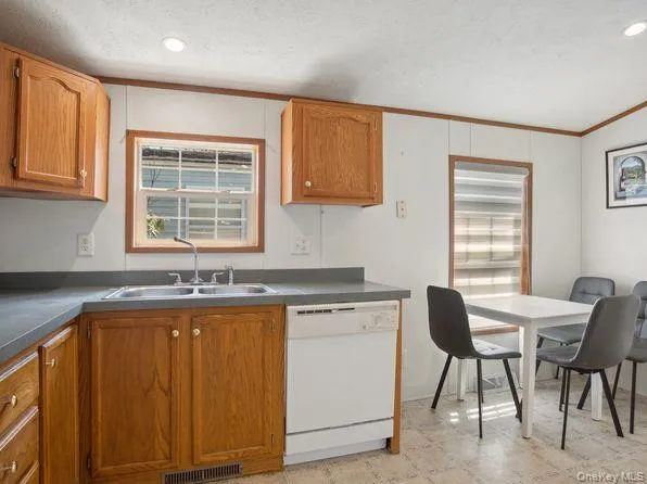 a kitchen with granite countertop sink stove and cabinets