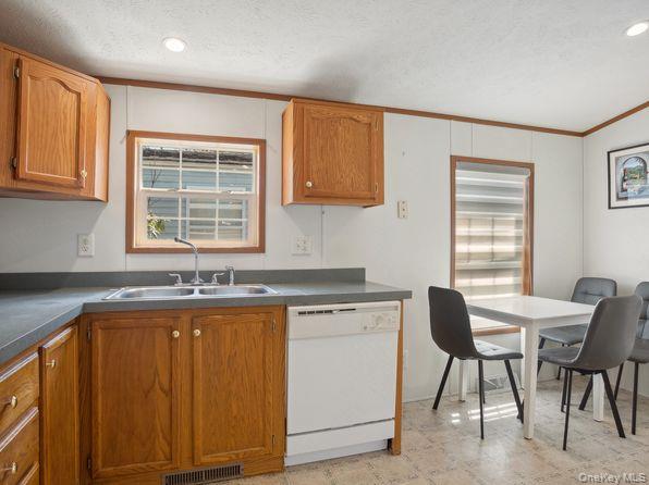 337 Three Mile Harbor Road, Unit 10 East Hampton, NY 11937 - Photo 9 of 16 a kitchen with granite countertop sink stove and cabinets