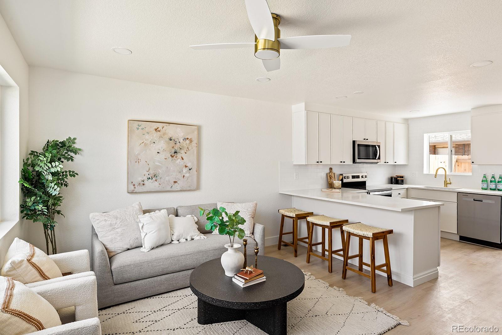 a living room with furniture kitchen view and a potted plant