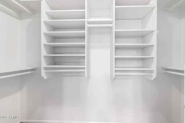 a view of a room with wooden floor and a ceiling fan