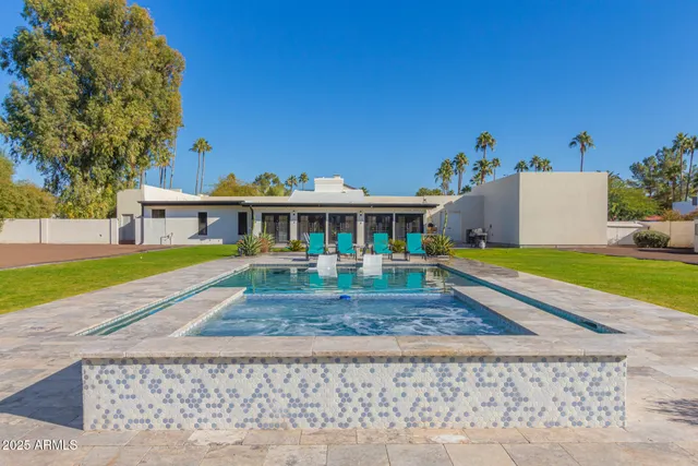 a view of house with swimming pool and a yard