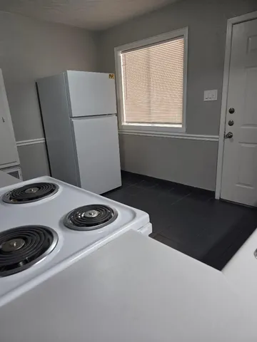 a kitchen with a stove and white cabinet