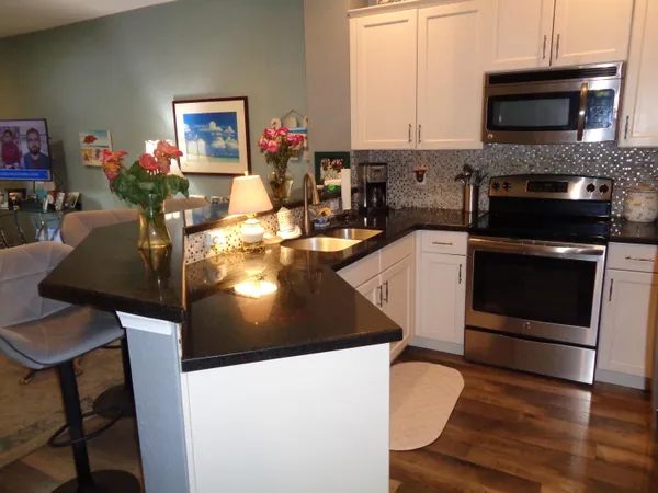 a kitchen with granite countertop a stove and white cabinets