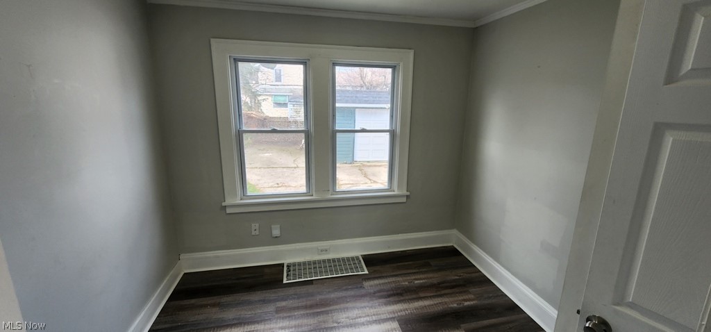 1514 Clermont Road Cleveland, OH 44110 - Photo 6 of 16 Empty room featuring crown molding and dark wood-style flooring