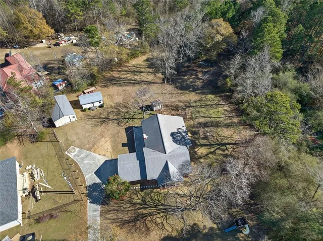 a large white kitchen with granite countertop a large window a sink and stainless steel appliances