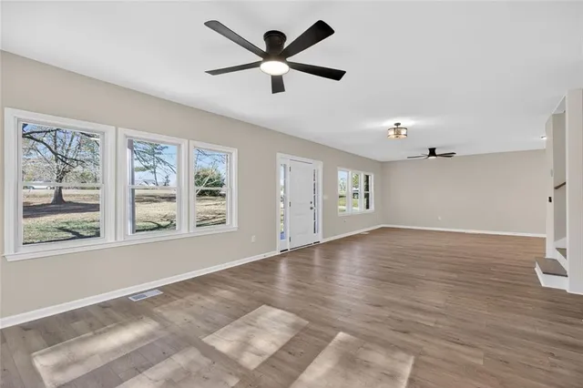a view of empty room with wooden floor and window