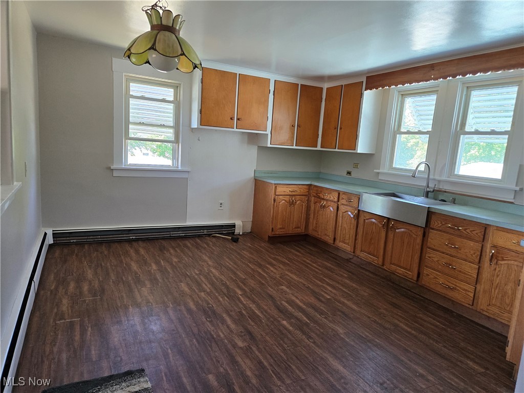 5555 Detroit Road Sheffield, OH 44054 - Photo 9 of 50 Kitchen featuring brown cabinets, dark wood finished floors, a baseboard radiator, and light countertops