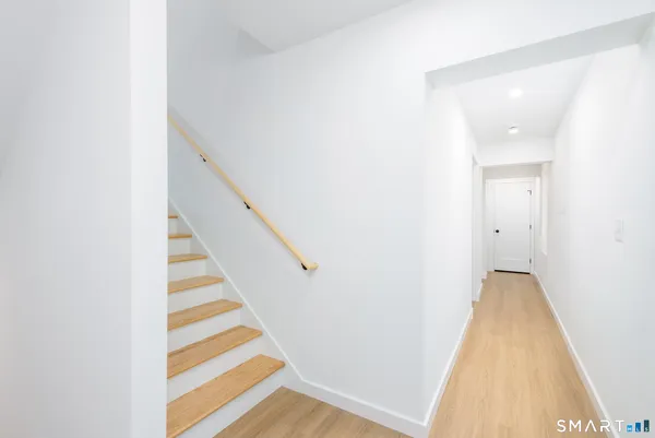 a view of a hallway with wooden floor and staircase
