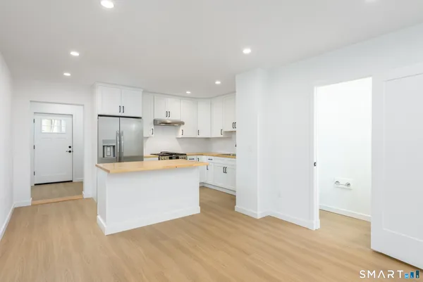 a kitchen with stainless steel appliances granite countertop a refrigerator and a stove top oven