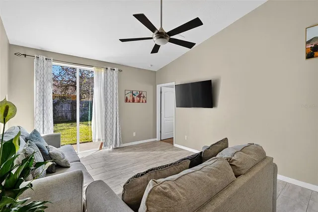 a bedroom with a bed a couch and a flat tv screen
