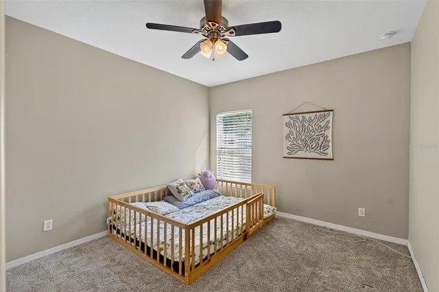 a bedroom with a bed and a chandelier fan