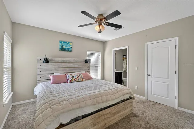 a bedroom with a large bed and ceiling fan