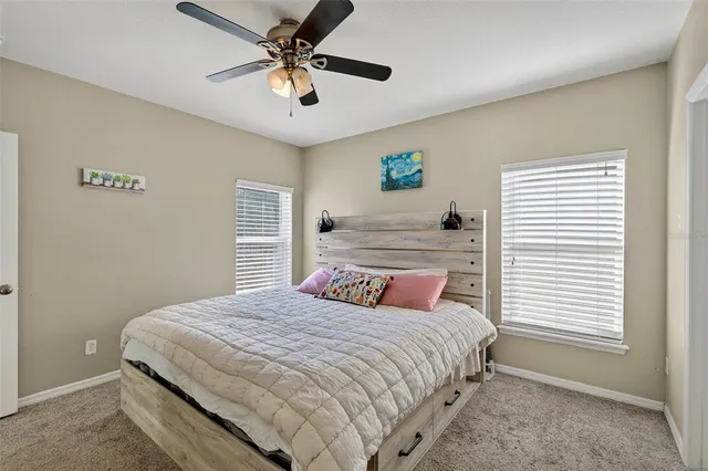 a bedroom with a large bed and a ceiling fan