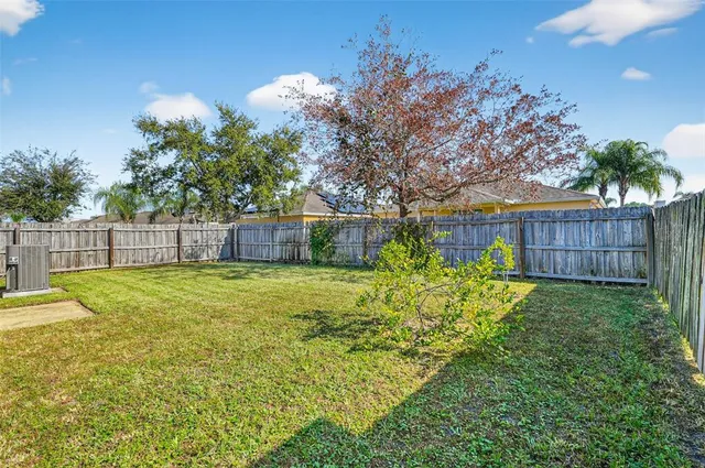 a view of a backyard with wooden fence