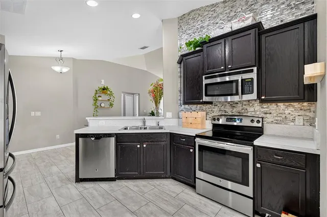 a kitchen with stainless steel appliances granite countertop a sink stove and microwave