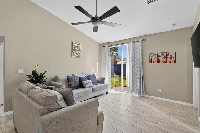 a living room with furniture and a ceiling fan
