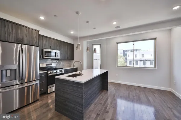 a kitchen with kitchen island white cabinets appliances and center island
