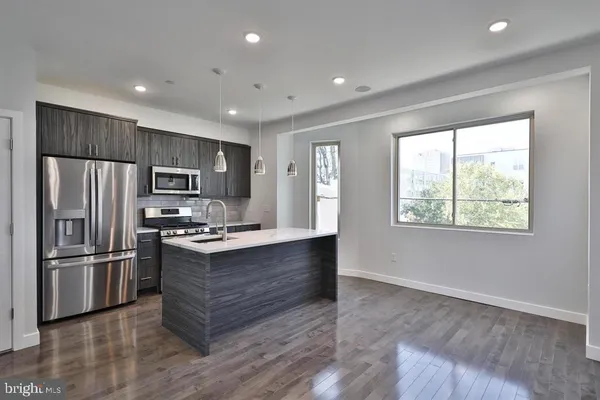 a kitchen with stainless steel appliances granite countertop a refrigerator and a stove top oven