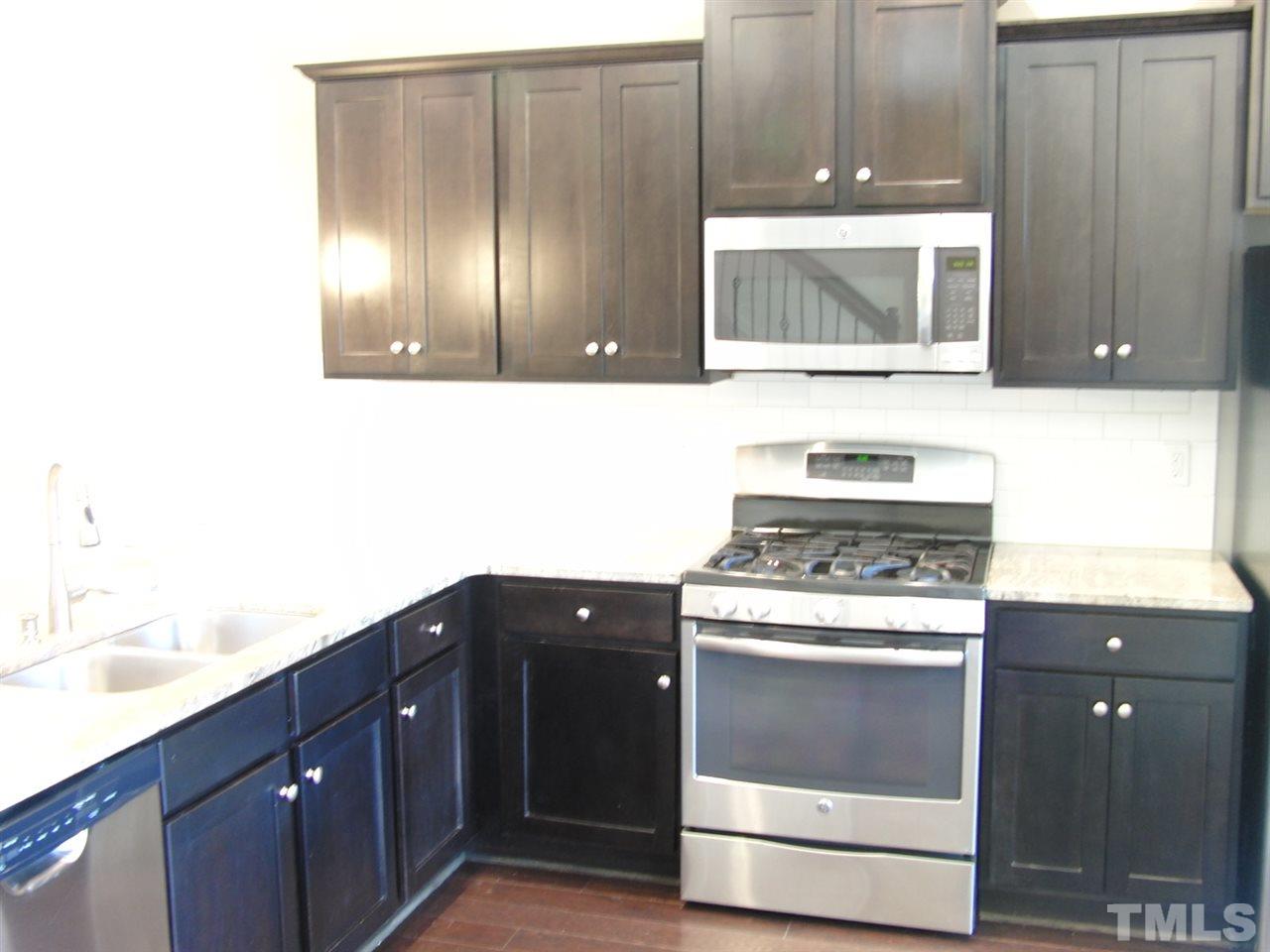 7893 Allscott Way Raleigh, NC 27612 - Photo 6 of 25 a kitchen with a sink and a microwave