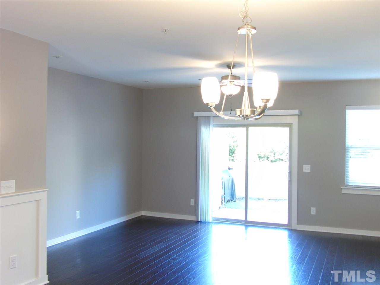 7893 Allscott Way Raleigh, NC 27612 - Photo 10 of 25 a view of a room with wooden floor chandelier and windows