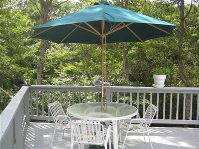 63 Monahansett Road Mashpee, MA 02649 - Photo 9 of 31 a view of a deck that has two chairs under an umbrella