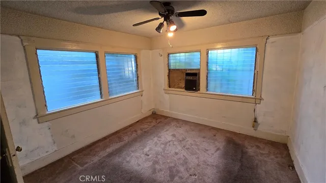 a view of an empty room with a ceiling fan