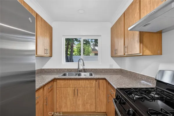 a kitchen with a refrigerator sink and cabinets