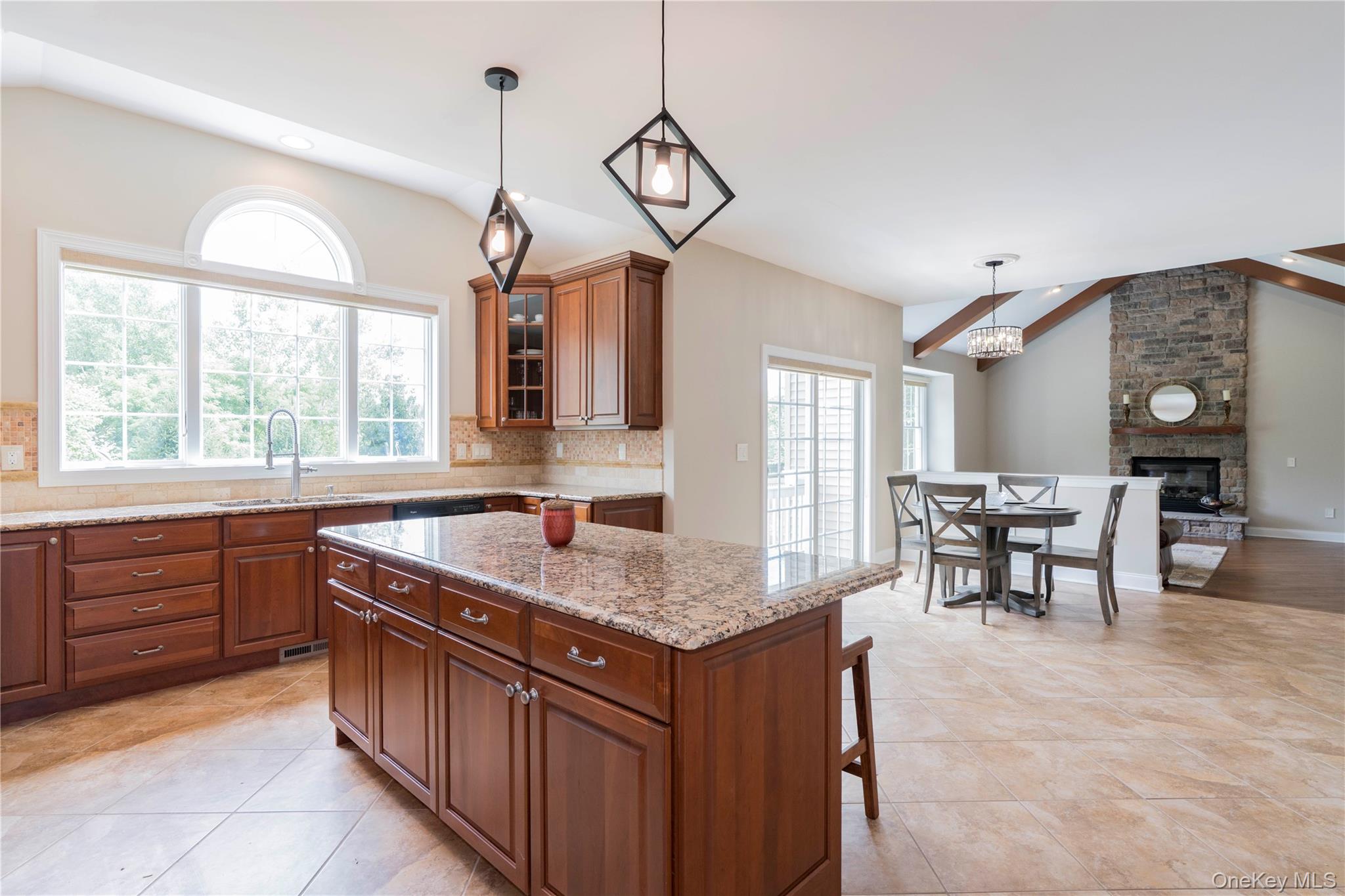 78 Moore Road Hopewell Junction, NY 12533 - Photo 11 of 38 Kitchen featuring backsplash, brown cabinets, pendant lighting, glass insert cabinets, and a breakfast bar