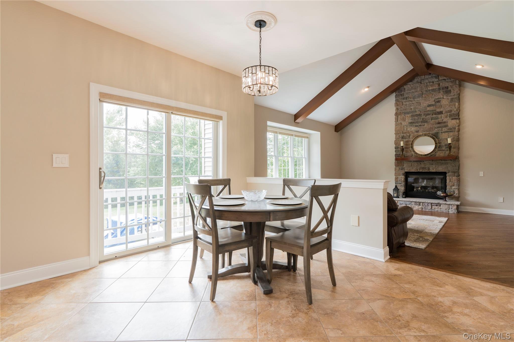 78 Moore Road Hopewell Junction, NY 12533 - Photo 16 of 38 Dining room featuring beam ceiling, a stone fireplace, light tile patterned floors, a chandelier, and recessed lighting